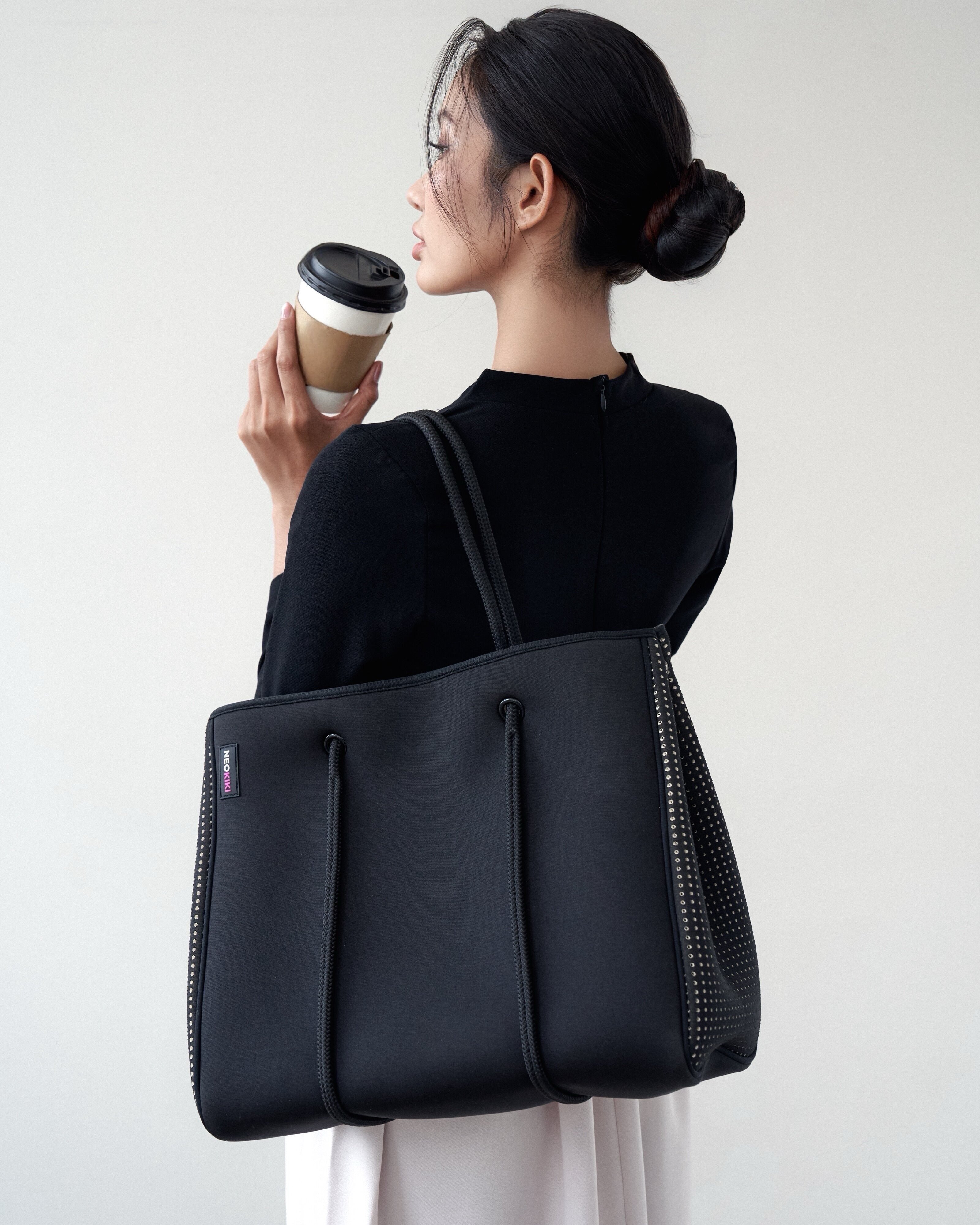 Woman carrying lightweight neoprene handbag