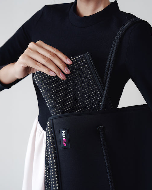 Woman carrying lightweight neoprene handbag
