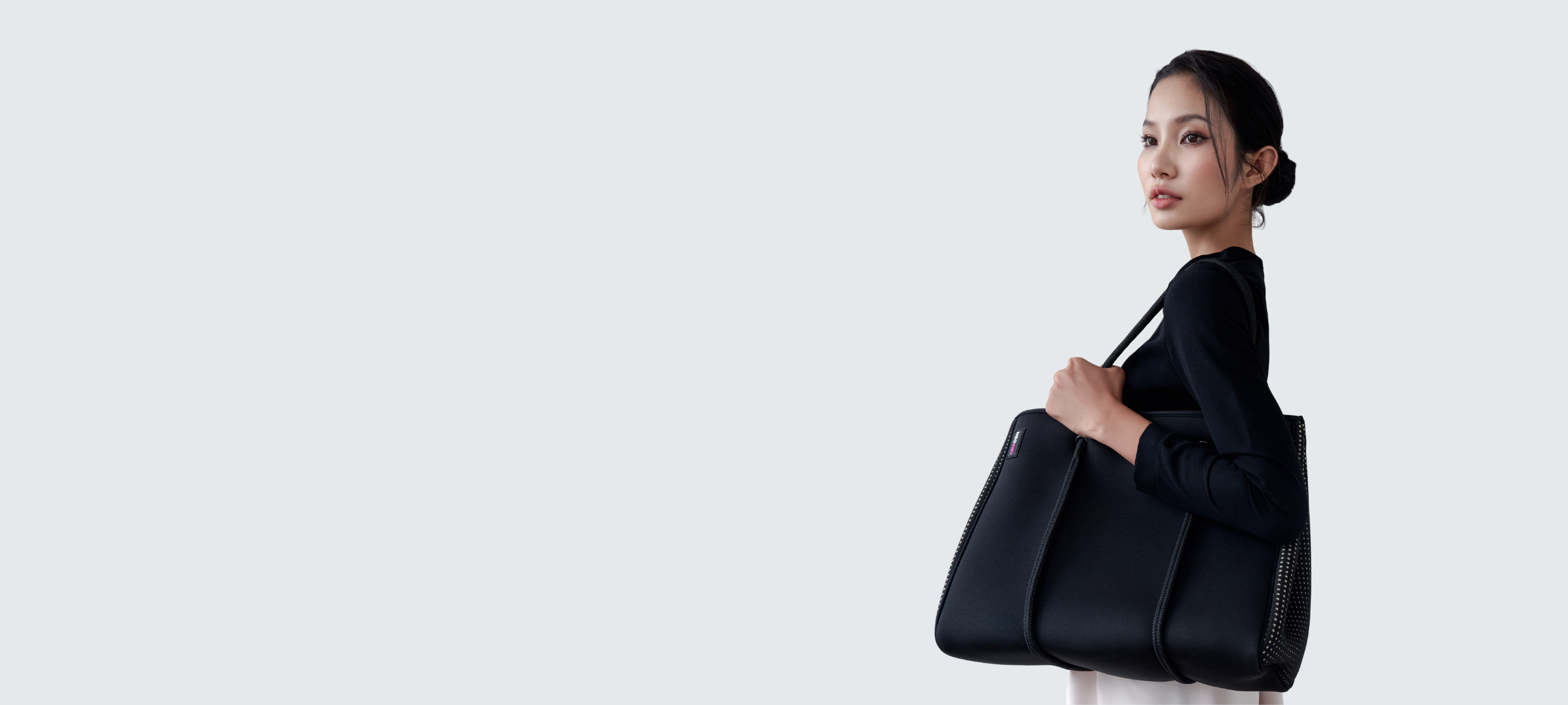 Woman carrying lightweight neoprene handbag